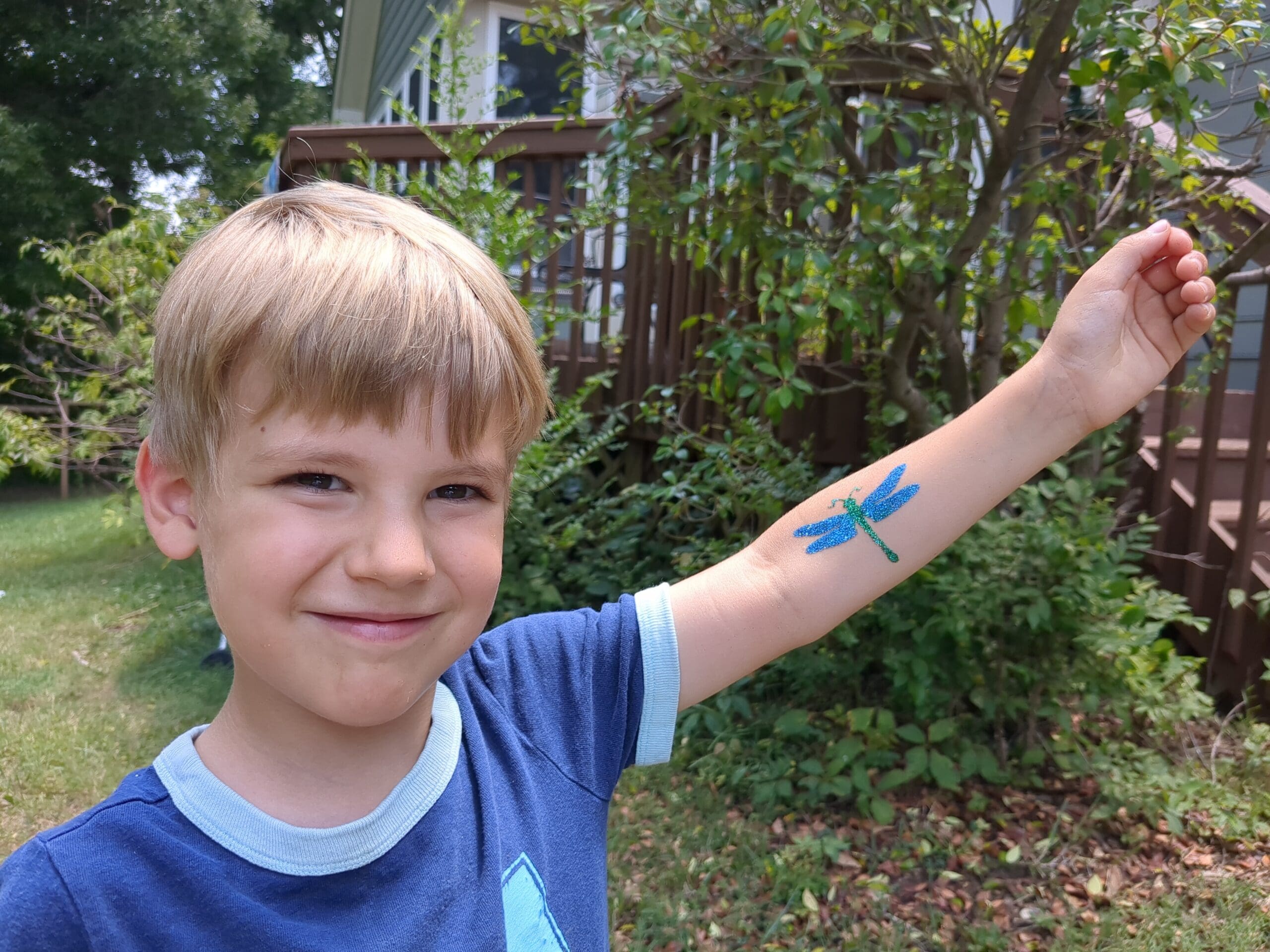 Boy with dragonfly glitter tattoo - Made Ya Look Foam Party boy with a dragonfly glitter tattoo on his arm