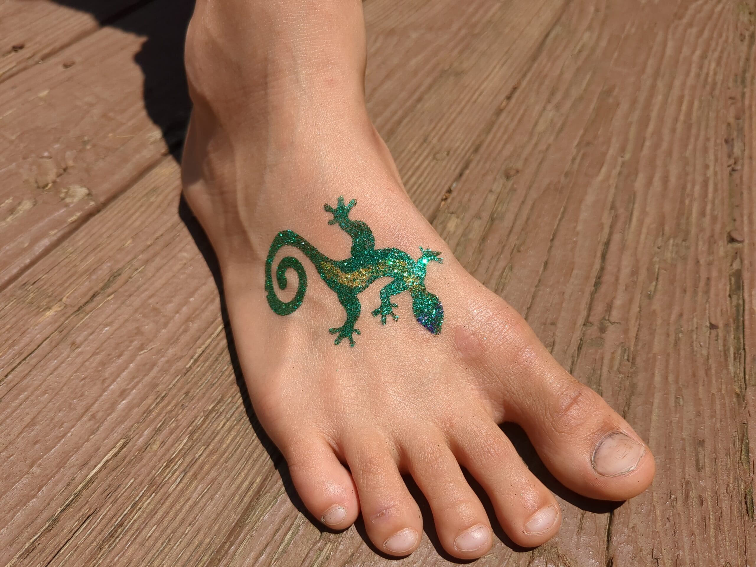 Green Lizard Glitter Tattoo - Made Ya Look Foam Party green and yellow lizard glitter tattoo on a foot at a pool party