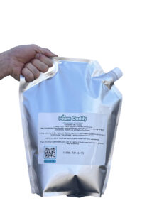 Hand gripping a foil pouch of Foam Daddy Ready-Foam Solution with a spout and label visible